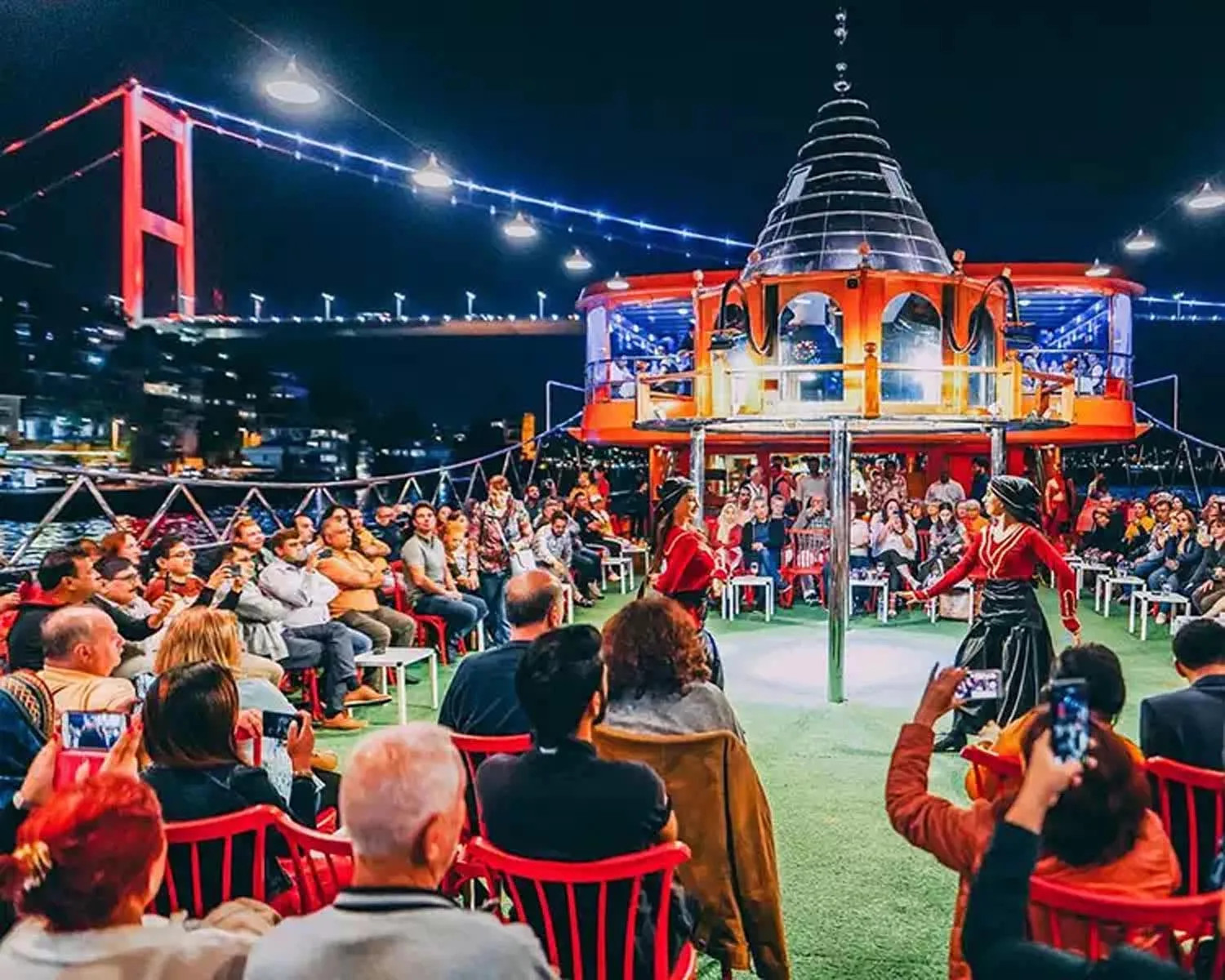 Guests at dinner on a Bosphorus cruise as Istanbul lights up at night